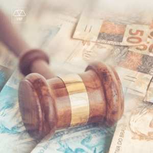 Um martelo representando a justiça está sobre um monte de notas de dinheiro, representando a busca por indenização na justiça.